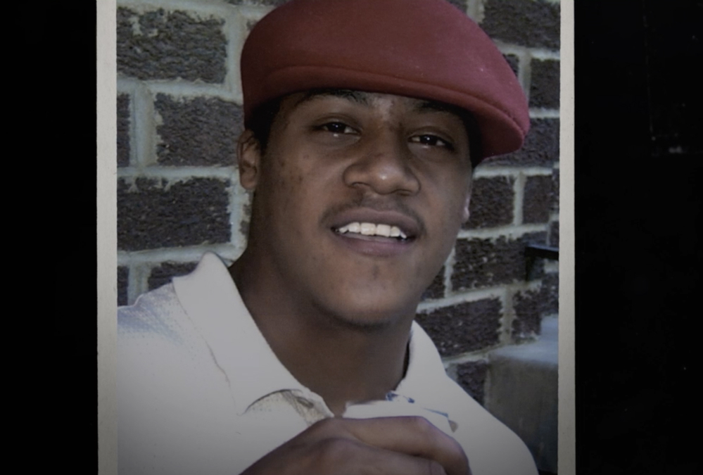 Alonzo in red cap and white polo shirt, smiling