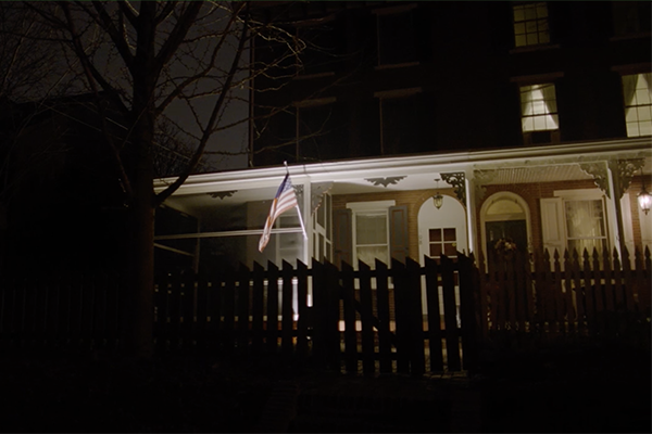 House with flag and fence at night