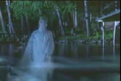 A translucent female in a white robe coming out of water.