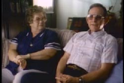 Jim and Kay Tatum are sitting on a couch in their living room.