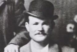 A black and white headshot of Robert LeRoy Parker, aka Butch Cassidy. He is wearing a suit and bowling hat.