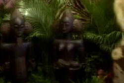 Two fertility statues placed in front of palm leaves