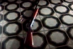 A shotgun laying on black and white tiled floor