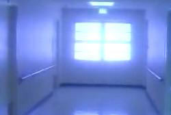 A white hallway with a large window at the end.