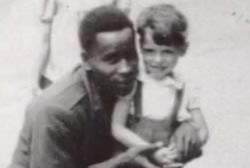 An african american man kneeling next to a small caucasian child.