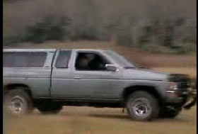 A gray pick up truck driving fast
