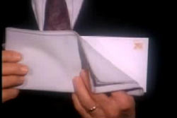 A man in a suit holding an envelope.