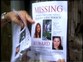 A missing poster for Claudia is stapled to the pole of a street light.