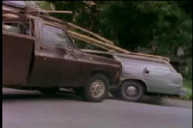 A brown pick up truck hits a light green station wagon on the driver's side.