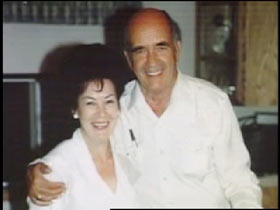 Jean Moore posing with Al Henderson, an elderly caucasian man with a bald head.