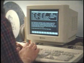 A person typing on large desktop computer.