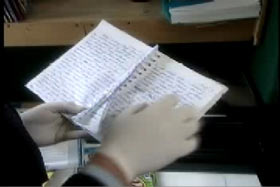 A person looking at a handwriting journal, the writing is ineligible.