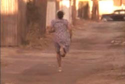 A woman in a dress running down an alley.