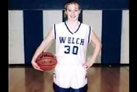 A caucasian teenage girl with blonde hair posing with a basketball and wearing her basketball uniform, Ashley Freeman.