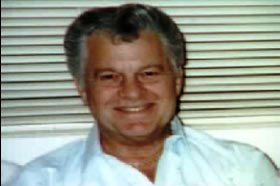 An middle aged caucasian man, Lee Young, wearing a white collared shirt with short grey hair.