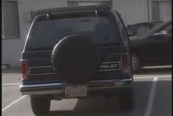 The back of a black Chevrolet SUV with a tire attached to the back.