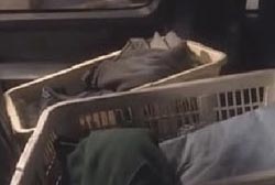 Two white baskets filled with folded laundry in the back seat of the SUV.