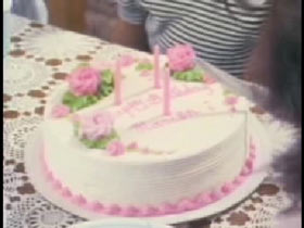 A birthday cake with white frosting and pink flowers.