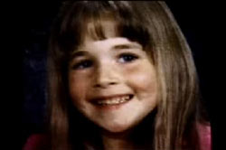 A young girl, Morgan Nick, posing for a school picture. She has long brown hair with bangs.