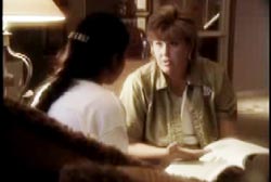 A woman with short brown hair is seated and talking to a woman with long dark hair.