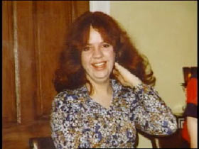 A middle aged woman, Pamela Page, with shoulder length red hair.