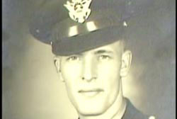 A caucasian man, Ray Hickenbotham, wearing a military uniform. His hat covers his hair.