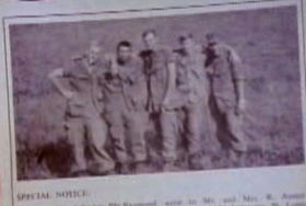 A magazine clipping of five military men posing for a photo in a field.