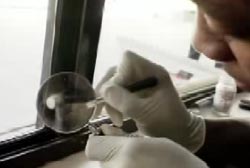 An investigator examining a window with a magnifying glass.