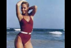 Tami Lynn Leppert posing on the beach in a red one piece bathing suit.