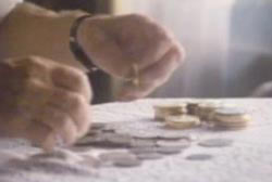 A person is organizing coins on a table.