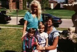 The Routier family posing on a sidewalk. The father has short brown hair and a full beard and the mother, Darlie, has long blonde hair.