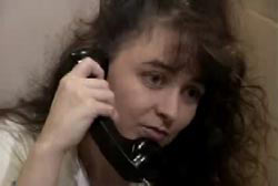 Darlie with long brown hair in prison talking to a visitor through the glass.