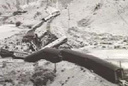 A black and white photo of the derailed train from a different angle.