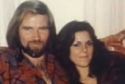 A young caucasian couple on a couch. Diana Robertson and Mike Riemer, Diana has long brown hair and Mike has long blonde hair.