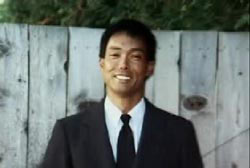 Smiling Eric Tamiyasu in a suit and tie