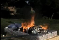 Mattress, sheets and pillows burning outside of a home