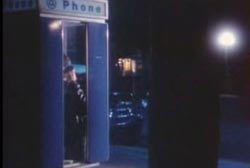 A man making a call at a phone booth