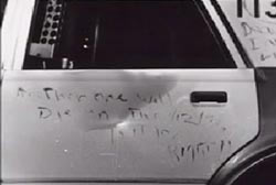 A cryptic message wtitten on the side door of a patrol car
