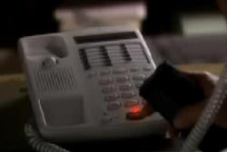 A person pressing buttons on a landline phone