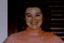 Smiling Jeanne Tovrea in an orange turtle neck