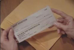 Hands holding a check over a manila envelope