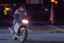 Hunter on his red white and blue motorcycle riding down the street