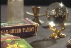A table with a pack of tarrot cards and a crystal ball