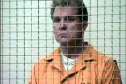 Michael Goodwin in an orange jumper behind bars