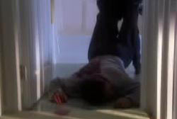 A man dragging Mikes body into the room of a house