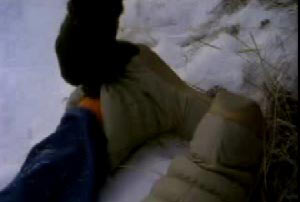 A man pulling down the boot of Annette to reveal an orange sock