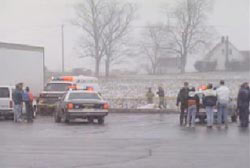 Police officers and Ambulance arrive at the location of the body in a snowy field outside of a truck stop