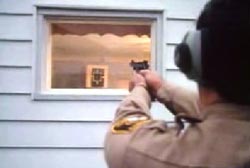 A police officer aiming his gun at the window where Ralph was shot
