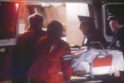 Police and EMT putting the covered body of Gryziec into the back of an ambulance
