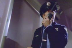 A security officer stading in a doorway radioing for other officers